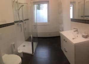 a bathroom with a shower and a toilet and a sink at zentral gelegene top ausgestattete Wohnung in Wurzen