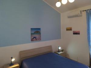 サン・ヴィート・ロ・カーポにあるRESIDENCE 3 STARs SAN VITO LO CAPOのベッドルーム1室(青いベッド1台、ランプ2つ付)