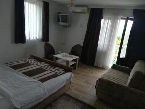 1 dormitorio con cama, sofá y TV en LAZAREV KONAK, en Banja Koviljača