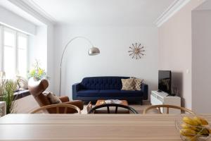 a living room with a blue couch and chairs at Casa Cosi - Eixample 2 in Barcelona