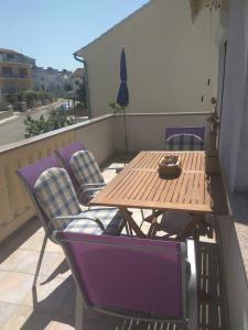y balcón con mesa y sillas de madera. en Apartments Mima, en Zadar