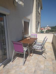 una mesa de madera y sillas en un patio en Apartments Mima, en Zadar