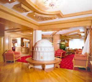 una hall con una grande stanza con tavolo e sedie di Hotel Diamant Park a Campitello di Fassa