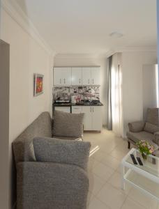 a living room with two couches and a kitchen at Mitos Apartments in Marmaris