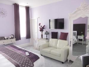1 dormitorio con cama, silla y espejo en FourRooms - Couples Only en Blackpool