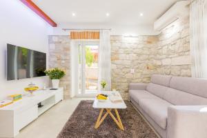 ein Wohnzimmer mit einem Sofa und einem Tisch in der Unterkunft Apartman Grgur in Split