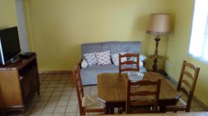 a living room with a table and a couch at Le 76 in Gamaches