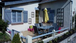 une terrasse avec une table, des chaises et un parasol dans l'établissement Le 76, à Gamaches