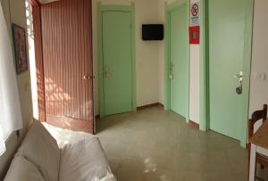アヴォラにあるCasa Vacanze Robinsonの緑のドアとソファが備わる廊下