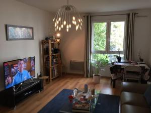 un soggiorno con divano e TV a schermo piatto di APPART 2 PIECES 50M2 COURBEVOIE / LA DEFENSE a Courbevoie
