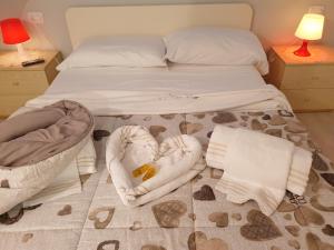 a bedroom with a bed with towels and a crib at Lo scrigno dei sogni in Polignano a Mare