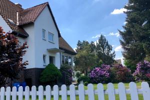 a white picket fence in front of a house at K House 5* Apartments in Kaufungen