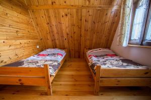 a room with two beds in a log cabin at Domek na Mazurach Pasym in Pasym