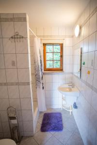 a white bathroom with a sink and a shower at Domek na Mazurach Pasym in Pasym