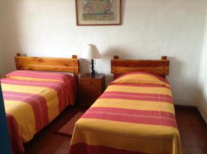 two beds sitting next to each other in a room at Hotel Santa Prisca in Taxco de Alarcón