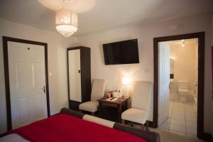 une chambre avec un lit, un bureau et une télévision dans l'établissement Birdsong Cottage Bed and Breakfast, à Chathill