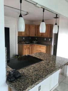 a kitchen with a granite counter top and two pendant lights at 82-10SW 135AV in Miami