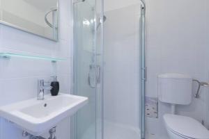 bagno bianco con lavandino e doccia di Apartment Cankar a Pola (Pula)