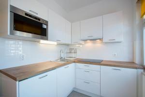 una cucina bianca con lavandino e forno a microonde di Apartment Cankar a Pola (Pula)