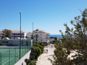 uitzicht op een tennisbaan en de oceaan bij Apartment Santa Eulalia Albufeira in Albufeira