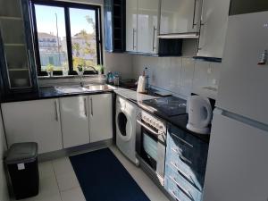 een keuken met een wastafel en een wasmachine bij Apartment Santa Eulalia Albufeira in Albufeira