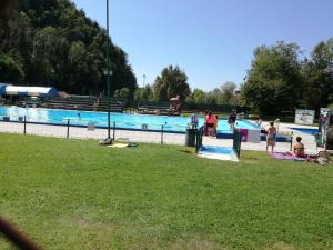 a swimming pool with people in a park at Počitniška hiška Pod Skalco in Kamnik