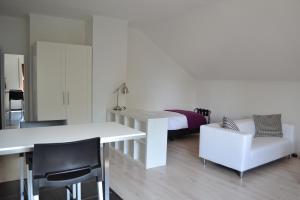 sypialnia z łóżkiem oraz białym stołem i krzesłami w obiekcie B&B Pommerloch w mieście Pommerloch