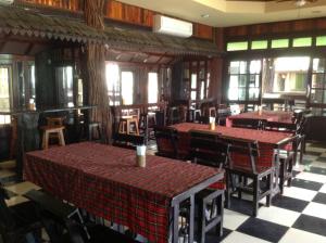 uma sala de jantar com mesas, cadeiras e janelas em Happy Resort Bandung em Ban Dung