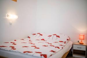 ein Schlafzimmer mit einem Bett mit roten Blättern darauf in der Unterkunft kažo in Rab