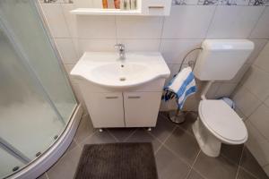 ein Badezimmer mit Waschbecken, Toilette und Dusche in der Unterkunft kažo in Rab