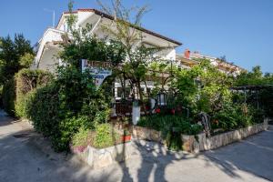 ein Haus mit Büschen und Blumen davor in der Unterkunft kažo in Rab