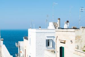 a white building with the ocean in the background at Donna Domenica Boutique Suites in Polignano a Mare