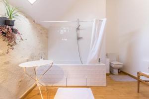 a bathroom with a bath tub and a toilet at La Thibaude - Livry in Livry
