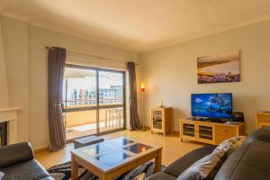 un salon avec un canapé et une télévision dans l'établissement The Hoffy Beach Apartment, à Lagos