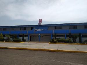 un bâtiment bleu avec un panneau à l'avant dans l'établissement Hotel Aeropuerto, à Toluca