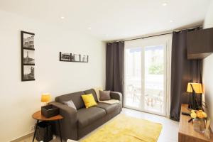 - un salon avec un canapé et une fenêtre dans l'établissement Le Petit Magellan, à Cannes