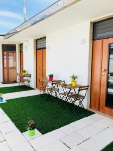a patio with a table and chairs and grass at Truly Apulia in Bari