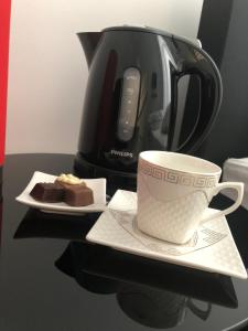 een kop koffie en een bord cake en een koffiepot bij Inga in Ieper