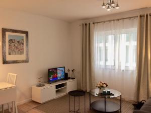 a living room with a tv on a white cabinet at CHARMING LIDO FLAT II in Funchal