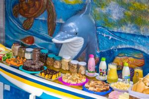 a table with food and a blue elephant head on it at Pousada Casa do Rio Hostel - 8 min do Centro Hístorico - Passeio de Barco com saída da Pousada -Pago a parte- Perto das Praias e Beira Rio in Paraty