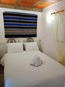 Un dormitorio con una cama blanca con una toalla. en Vitória House en Évora