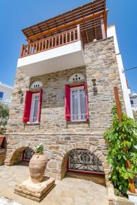提諾斯的住宿－Central Tinos Island Maisonette，砖砌的建筑,有红色的窗户和花瓶