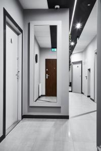a hallway with a door and a mirror at Compact Studios Słowackiego Avenue in Krakow