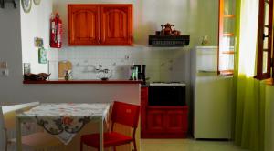 a kitchen with a table and a refrigerator at Lefteris Studios in Lefokastro
