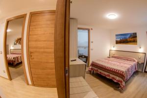 アオスタにあるMaison de Rosy Chambresのベッドルーム1室(ベッド1台付)と部屋のドア1室が備わります。