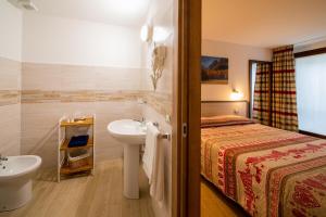 アオスタにあるMaison de Rosy Chambresのバスルーム(ベッド1台、トイレの隣に洗面台付)