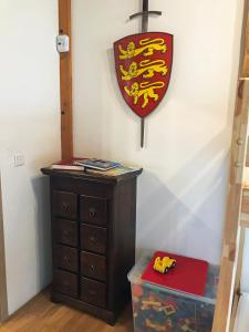 a shield hanging on a wall next to a dresser at Ferienwohnung LATERNENSTUBE mit großem Familienbett für 8 Personen in Leppersdorf