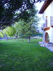 a park with a tree and a swing set at Apartamentos Cañones de Guara y Formiga in Panzano