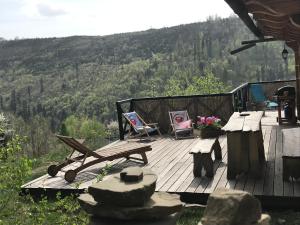 a deck with two chairs and a picnic table with a view at Dom Kawa na Kotarzu in Brenna