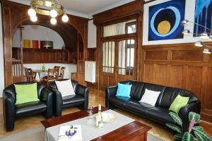 a living room with two black leather chairs and a table at Beletage (Villa) in Eisenach